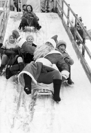 Дед Мороз на санках катится с горки вместе с детьми. Зимний детский лагерь, Московская область, 1984 г.