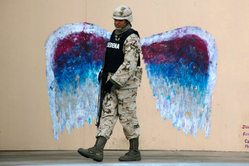 22. Удачный кадр, запечатлевший солдата на фоне граффити с изображением крыльев ангела. 