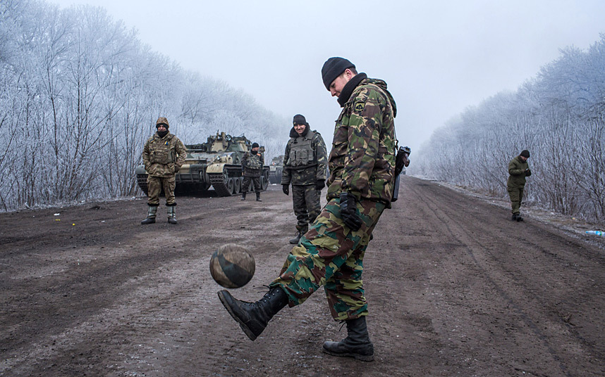 27. Донбасс после перемирия. Украинские военные играют в футбол на дороге, возле Дебальцева. 