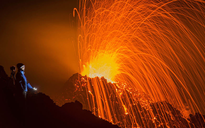 30. Турист наблюдает извержение вулкана Питон-де-ла-Фурнез.