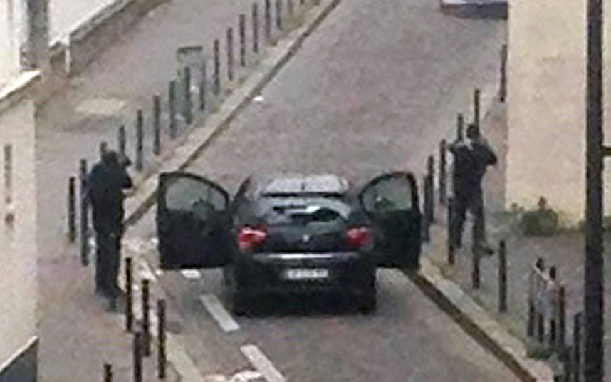 8. Вооруженные боевики обстреливают полицейских возле офисов французской сатирической газеты Charlie Hebdo в Париже. Фото: AFP / Getty Images.