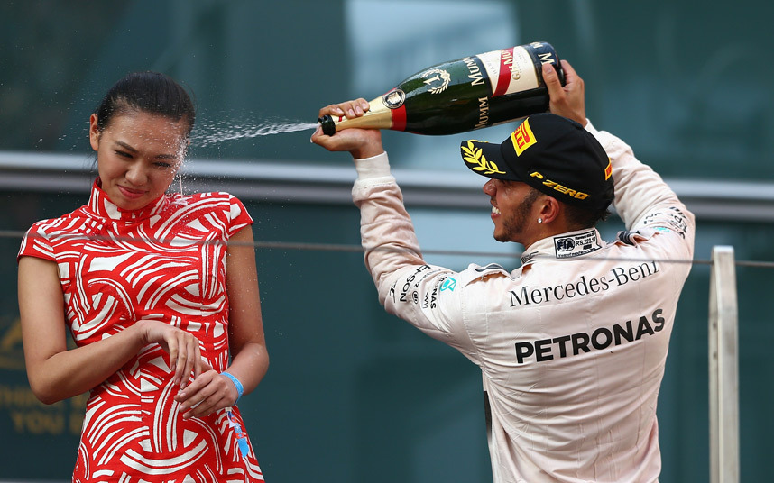 11. Пилот Формулы 1 Льюис Хэмилтон обливает девушку шампанским.