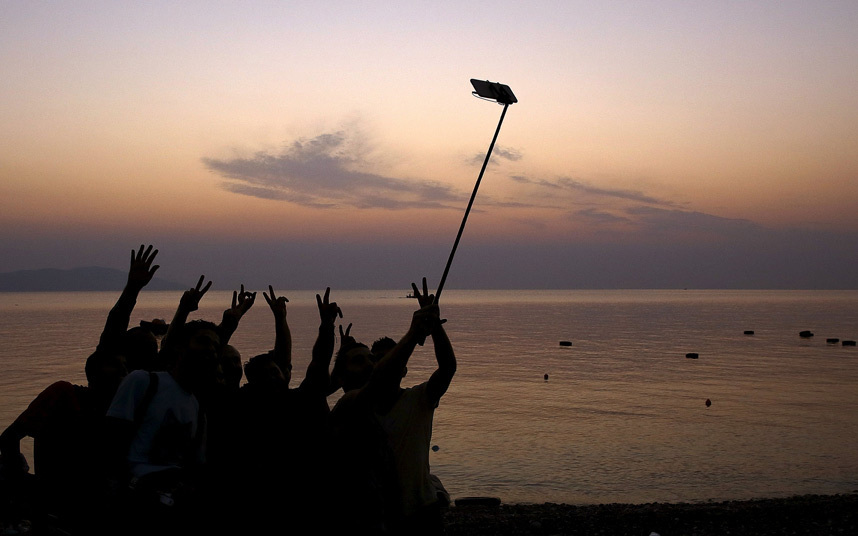 25. Сирийские беженцы делают селфи после прибытия на греческий остров Кос.