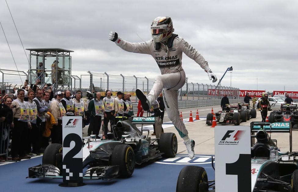 37. Гонщик Формулы 1 Льюис Хэмилтон прыгает возле своего Мерседеса после победы в гонке. 