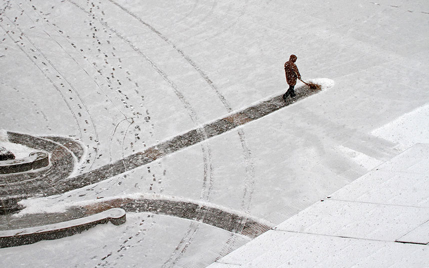 12. Рабочий очищает снег возле больницы в Яньтай, провинция Шаньдун.