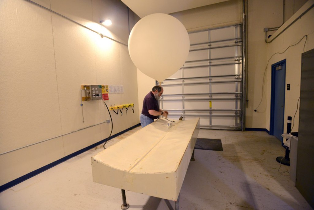 31. Сотрудник метеорологической станции Зигги Бойтор готовит к запуску метеорологический зонд.