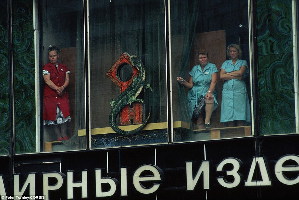 14. Три работницы универмага в Москве смотрят из окон на похоронную процессию жертв переворота.