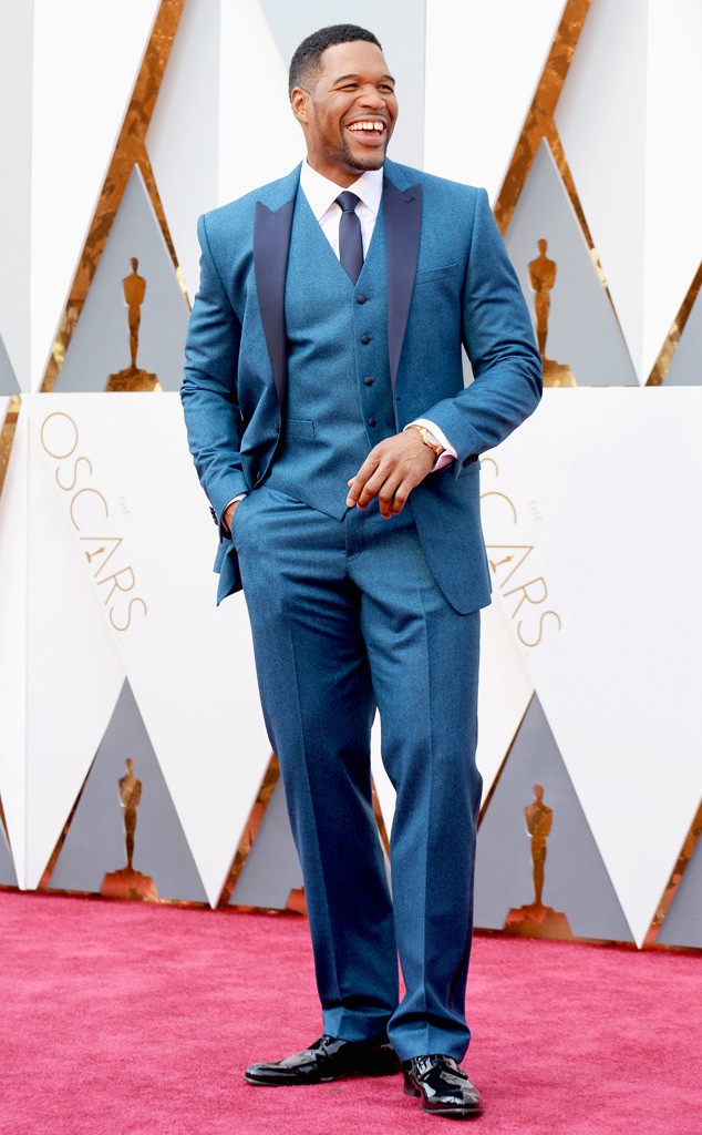 6. Ведущий Майкл Страхан одетый в синий костюм-тройку.