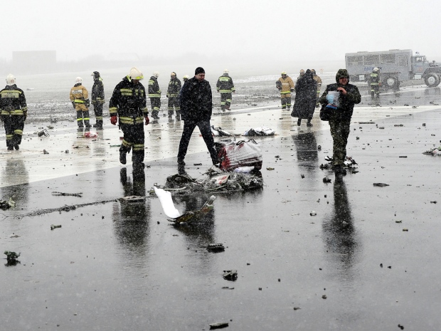 3. Спасатели и следователи работают среди обломков пассажирского самолета.