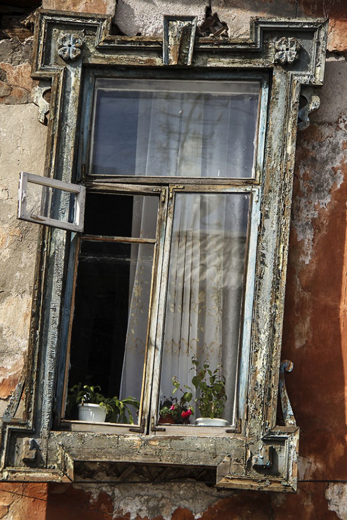 6. Очень старое окно, но обратите внимание на чистые занавески и цветы на подоконнике. Кажется хозяину нравится его окошко.