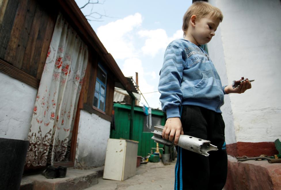 1. Мальчик держит в руках остатки минометного снаряда который попал в жилой дом в поселке Старомихайловка, Донецкой области. 
