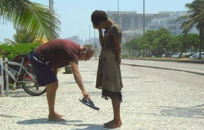 3. Мужчина отдает свою обувь бездомной девочке в Рио-де-Жанейро.
