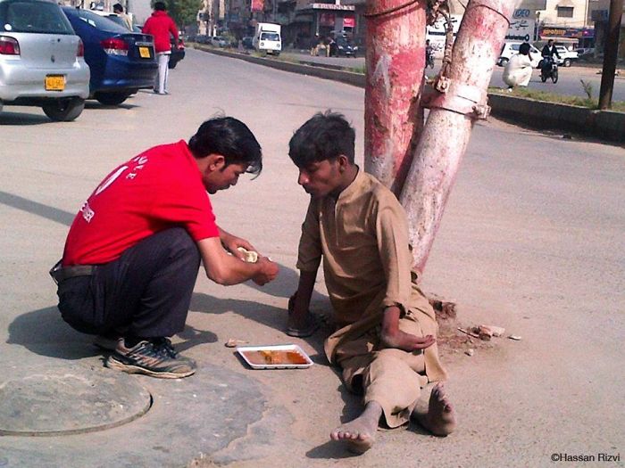 4. Пакистанский официант кормит бездомного, который не может использовать свои руки.