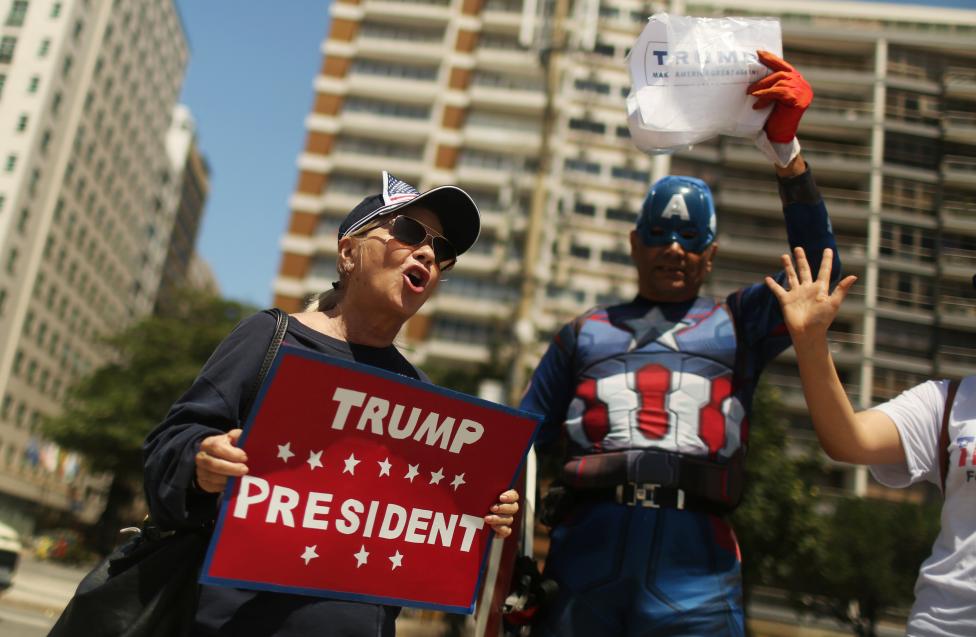 5. Сторонники Дональда Трампа держат таблички в его поддержку. Пляж Копакабана в Рио-де-Жанейро, Бразилия. Фото REUTERS / Pilar Olivares