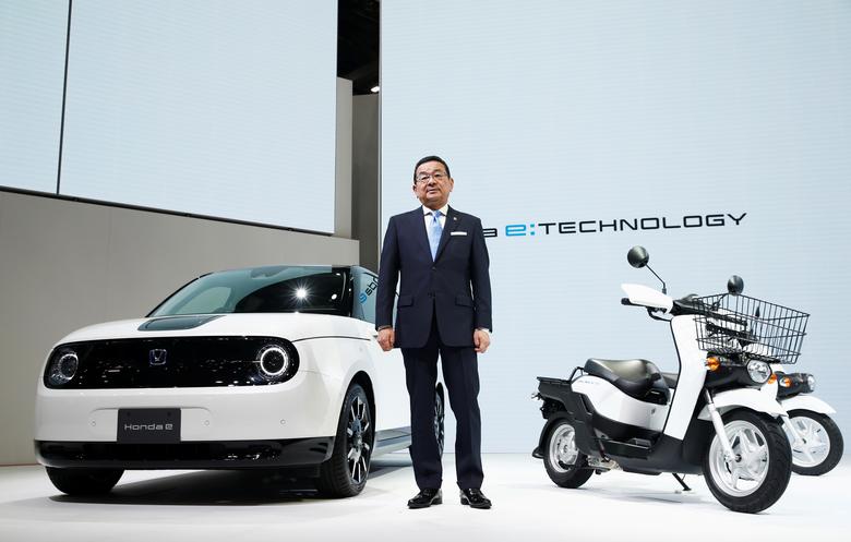 13. Президент и главный исполнительный директор Honda Такахиро Хатиго позирует рядом с электромобилем Honda e и электрическим скутером Honda Benly.