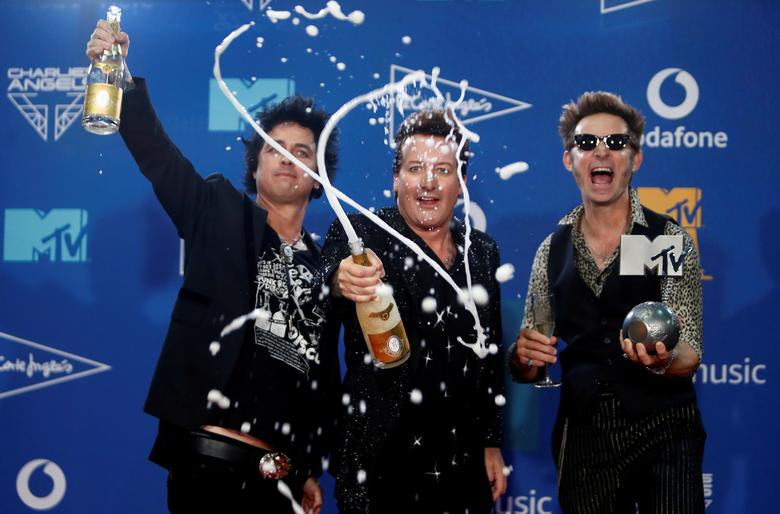 10. Участники Green Day празднуют за кулисами с шампанским.